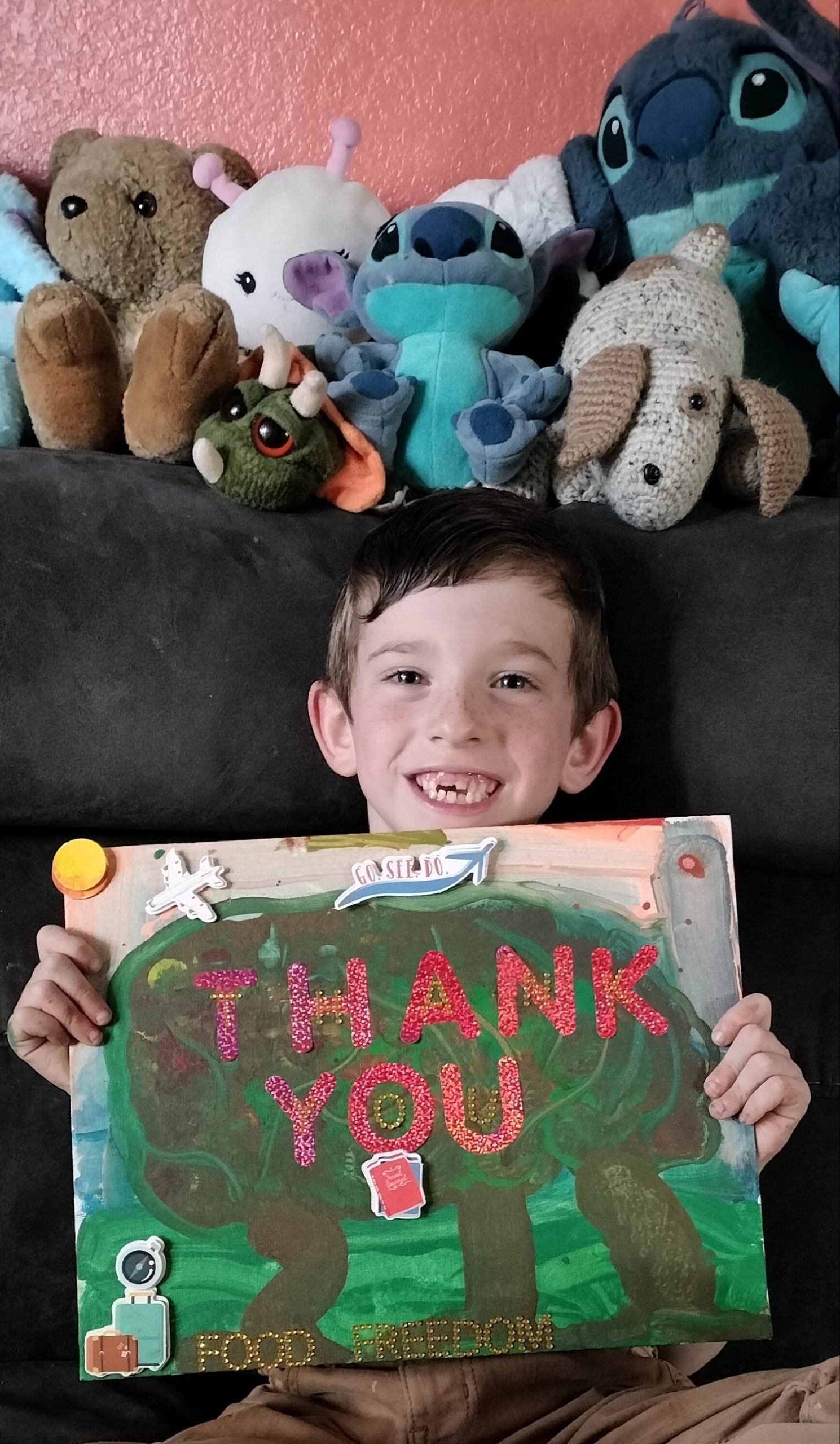 Smiling boy holding a "Thank you" sign