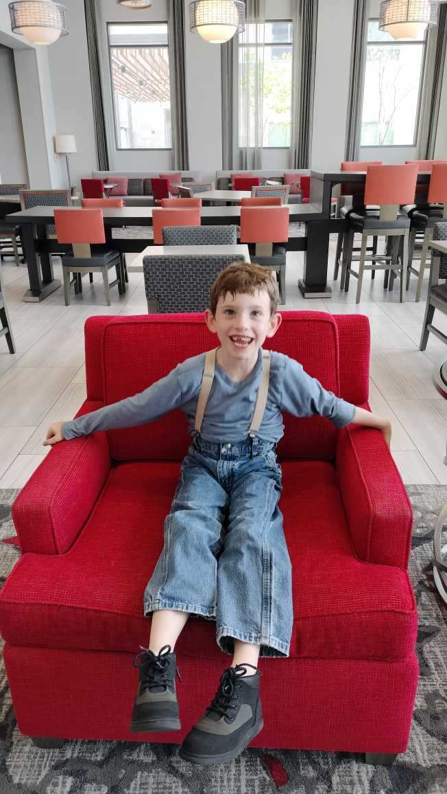 Smiling boy sitting on a red couch
