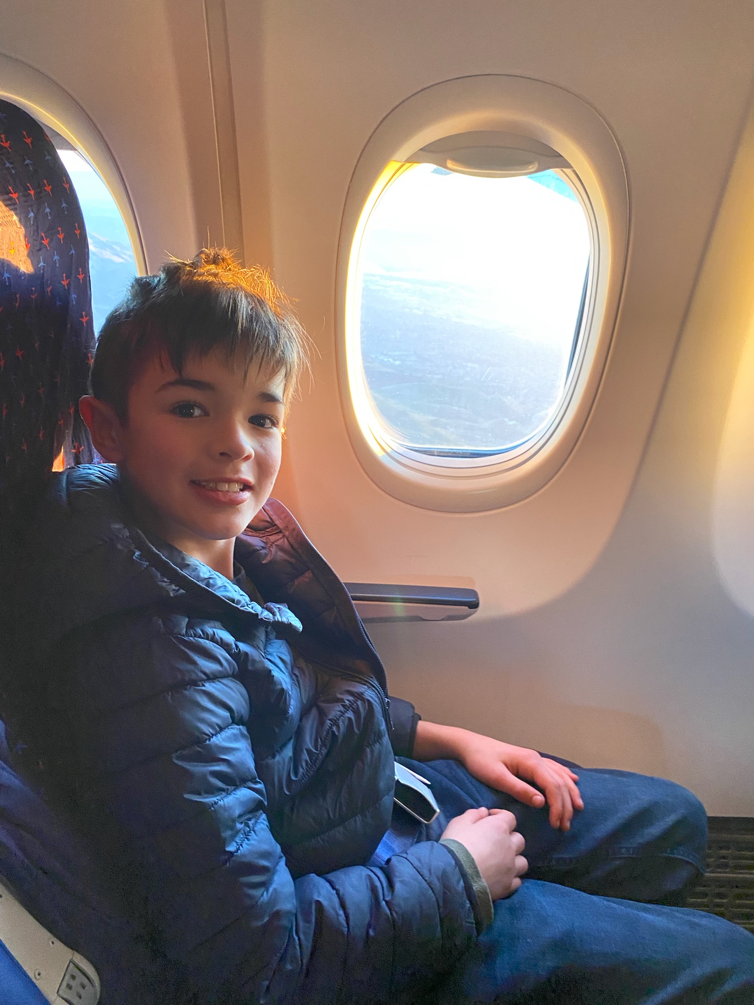 Boy on an airplane seat, next to the window